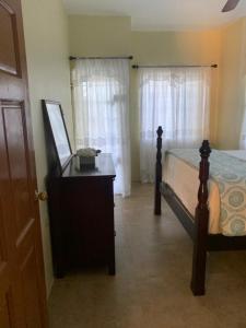 a bedroom with a bed and a dresser with a mirror at Rio View Apartments in Ocho Rios
