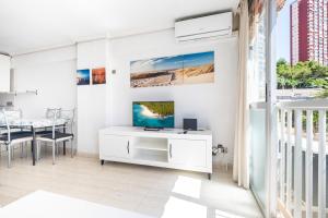 uma sala de estar com uma secretária branca e uma televisão em Carabelas III 1-3 Apartment Levante Beach em Benidorm