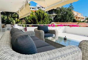 un patio con sedie in vimini e un divano di Sea, La Vie a Saronida