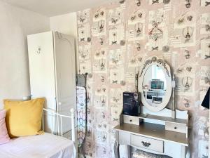 1 dormitorio con espejo, 1 cama y vestidor en Happy Place with kitchenette- female only, en Sydenham