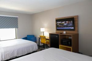 a hotel room with a bed and a flat screen tv at Days Inn by Wyndham Farmville in Farmville