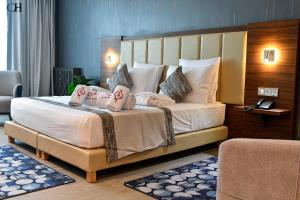 a bedroom with a large bed with pillows on it at Hotel Chaker in Batna