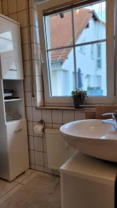 a bathroom with a sink and a window at Berlin-Oase - schnuckelige Ferienwohnung an der Grenze zu Berlin in Schönefeld
