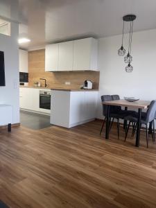 a kitchen and dining room with white cabinets and a table at See- & Bergblick Oberteuringen 59 mit beheiztem Indoor-Pool in Oberteuringen