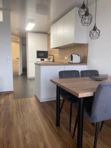 a kitchen and dining room with a wooden table and chairs at See- und Bergblick Oberteuringen in Oberteuringen