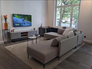 a living room with a couch and a flat screen tv at luxe en authenticiteit in Antwerp