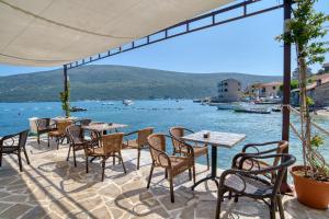 d'une terrasse avec tables et chaises et vue sur l'eau. dans l'établissement Garni Hotel Milica, à Herceg-Novi
