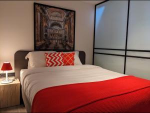 a bedroom with a large bed with a red blanket at luxe en authenticiteit in Antwerp