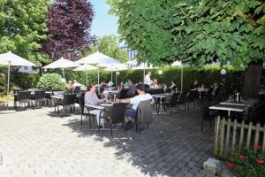 a group of people sitting at tables in a restaurant at Hotel Ristorante Schlössli in Luzern