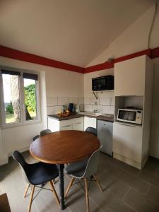 a kitchen with a table and chairs in a room at Studio meublé et équipé avec jardin et terrasse privée in Beurlay