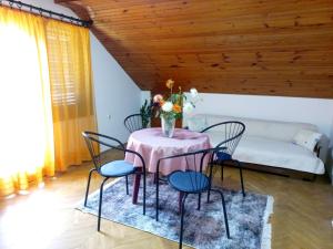 ein Esszimmer mit einem Tisch mit Stühlen und einem Sofa in der Unterkunft Apartman Alex 7 in Bajina Bašta