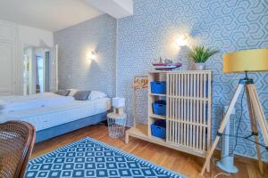- une chambre avec un lit et un mur bleu dans l'établissement ROYAN - Villa La Cigale - 7 chambres / 16 couchages, à Royan