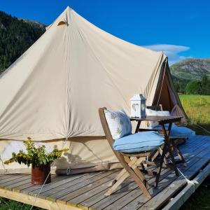a chair and a table in front of a tent at Flatheim Glamping in Viksdalen