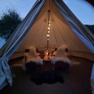 a tent with two chairs and a table inside at Flatheim Glamping in Viksdalen