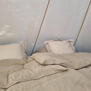 an unmade bed with two pillows on top of it at Flatheim Glamping in Viksdalen