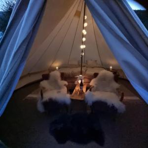 a group of chairs in a tent with blue curtains at Flatheim Glamping in Viksdalen