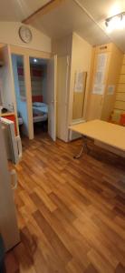 Mobil home 6-8 places en Camping 4etoiles Saint Cyprien في سان سيبريان: غرفة مع أرضية خشبية وغرفة مع ساعة