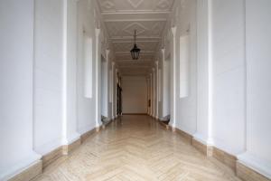 un couloir vide avec des murs blancs et un plafond dans l'établissement HT Residence Maximus, à Rome
