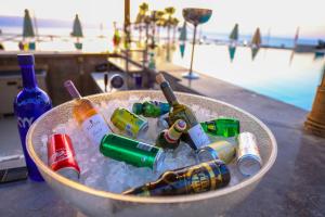 einen Eimer voller Flaschen in Eis neben einem Pool in der Unterkunft O Beach Hotel & Resort in Sowayma