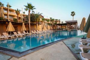 a large swimming pool with chairs and umbrellas at O Beach Hotel & Resort in Sowayma
