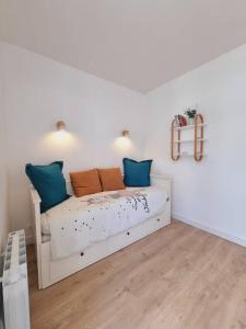 1 dormitorio con 1 cama con almohadas azules y naranjas en L'Eucalyptus - Centre ville - Terrasse, en Pontivy