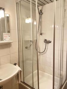 a bathroom with a shower and a sink at Hotel zum Markgrafen in Lüdenscheid