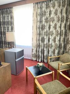 a living room with a table and chairs and a window at Hotel zum Markgrafen in Lüdenscheid