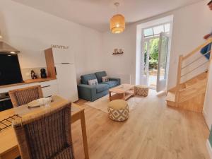 a living room with a table and a blue couch at L'Eucalyptus - Centre ville - Terrasse in Pontivy