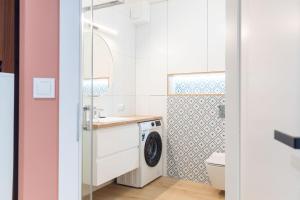 ein Badezimmer mit Waschmaschine und Waschbecken in der Unterkunft Green Leaf Jawor Apartamenty in Jawor