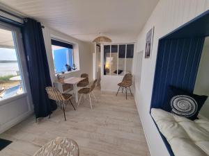a living room with a table and chairs at Petite maison avec jardin face mer in Agon-Coutainville