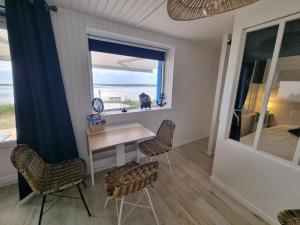 um quarto com uma mesa e cadeiras e uma janela em Petite maison avec jardin face mer em Agon Coutainville