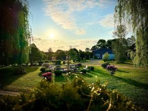 a garden with flowers and a blue building in the background at Agroturystyka Hotel Noclegi Pałac Camping in Wałcz