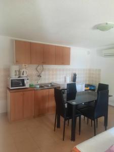 a kitchen with a table and chairs and a microwave at Apartment Anić in Šmrika