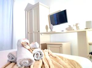 a bedroom with towels and a tv on a bed at Golden House in Porto Torres