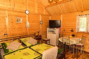 ゴウダプにあるdomek na Mazurachのベッド2台、テーブル、テレビが備わる客室です。