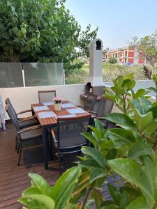 a wooden table and chairs on a deck with a fireplace at Kalisti Relax Villa in Nikiti +32 photos