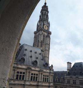 un grand bâtiment avec une tour d'horloge en arrière-plan dans l'établissement "Au pied du Beffroi" - Superbe emplacement, à Arras