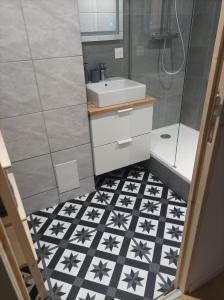 een badkamer met een zwart-witte tegelvloer en een wastafel bij Sweet Home in Mulhouse
