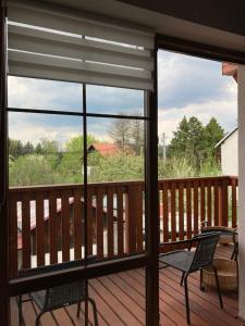 a view from a deck with two chairs and a window at Uroczy Apartament u Mirki in Podgórzyn