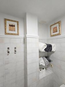 a white bathroom with a shower and towels at Fantastico estudio en Benalbeach con vistas al mar in Benalmádena
