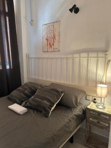 a bed in a bedroom next to a table with a lamp at Fantastico estudio en Benalbeach con vistas al mar in Benalmádena