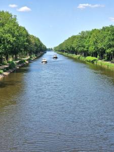 メッペンにあるExklusive Ferienwohnung in Meppenの両側に木々が並ぶ川上二隻