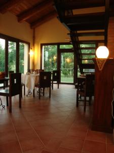 una sala da pranzo con tavolo, sedie e finestre di Agriturismo L'Unicorno a Portomaggiore