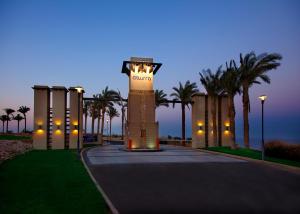 a clock tower in a park with palm trees at night at Azzurra Sahl Hasheesh in Hurghada