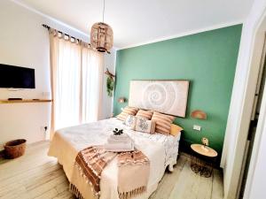 een slaapkamer met een bed en een groene muur bij Golden House in Porto Torres