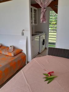 a bedroom with a bed and a table with a flower on it at Bungalow Miwa in Punaauia