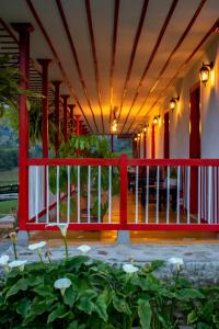 a porch with a red railing and a fence at San Remo Ecolodge in Santa Rosa de Cabal