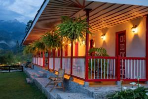 a house with a red and white porch with palm trees at San Remo Ecolodge in Santa Rosa de Cabal