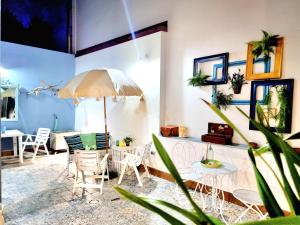 een patio met een tafel en stoelen en een parasol bij Golden House in Porto Torres