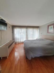a bedroom with a large bed and a wooden floor at Hostería Valle Verde 